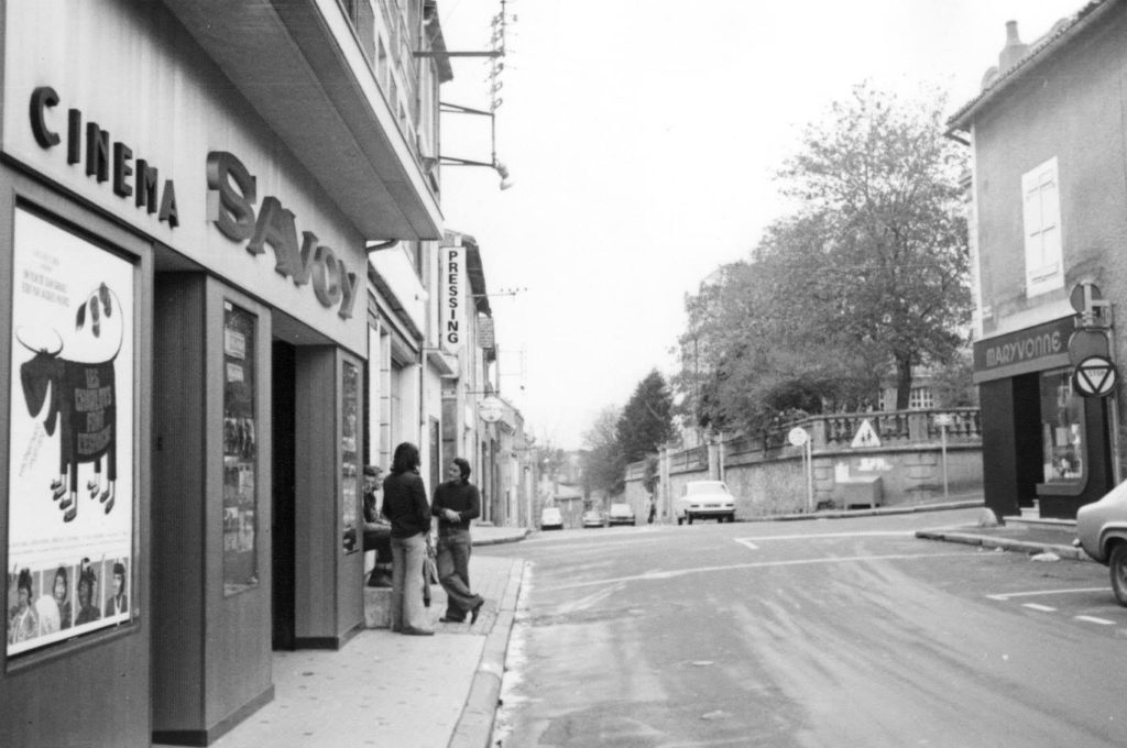 Vue sur la rue Anatole France avec Le Savoy à gauche et deux hommes qui discutent